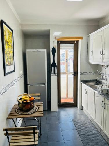 a kitchen with a table with a bowl of fruit on it at Casa do Souto - City in Bragança