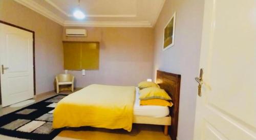 a bedroom with a bed with yellow sheets and yellow pillows at Belle maison familiale spacieuse à Dakar Sénégal HOME TERANGA in Dakar
