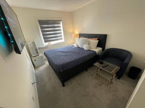 a small bedroom with a bed and a chair at Fresh Home in Oshawa