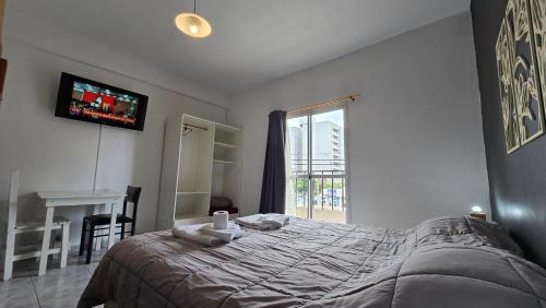 a bedroom with a bed and a tv and a window at Vida, hotel de playa in Puerto Madryn