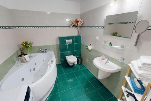 a bathroom with a tub and a toilet and a sink at Penzion Pohoda in Trutnov