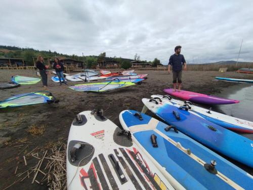 a group of people standing on a beach with kayaks at Vichuquen Lodge y Marina in Vichuquén