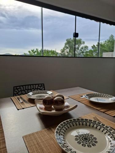 a table with plates and bowls on top of it at Chalé Fortuna in Miguel Pereira