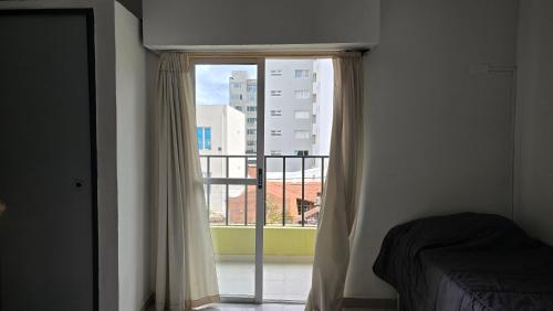 a bedroom with a window with a view of a building at Vida, hotel de playa in Puerto Madryn