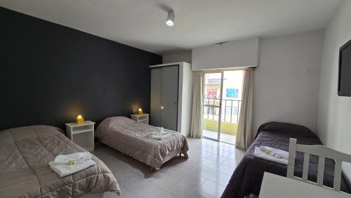 a bedroom with two beds and a window at Vida, hotel de playa in Puerto Madryn