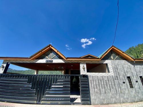 a building with stairs and a blue sky at Entire Holiday Home in Galiyat with Valley Views in Khaira Gali