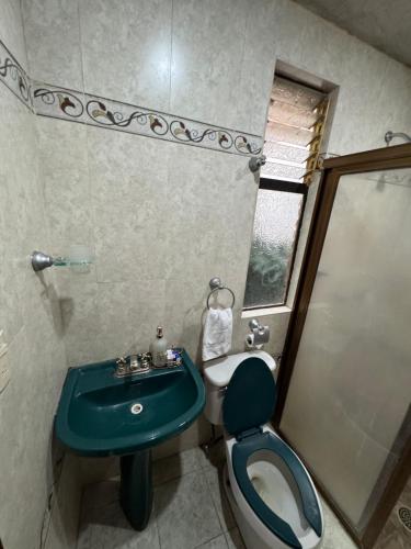 a bathroom with a green sink and a toilet at Un lugar muy bien ubicado in Morelia