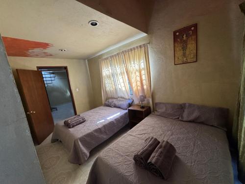 a bedroom with two beds and a window at Un lugar muy bien ubicado in Morelia