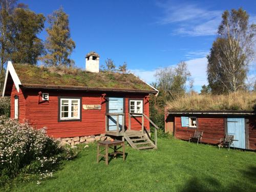 une petite maison rouge avec un toit en gazon dans l'établissement STF Tivedstorp, à Tivedstorp