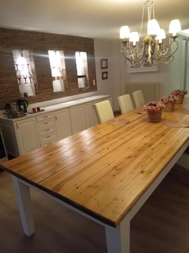 a kitchen with a wooden table and a dining room at Meteora Grande luxury suite & spa villa in Kalabaka