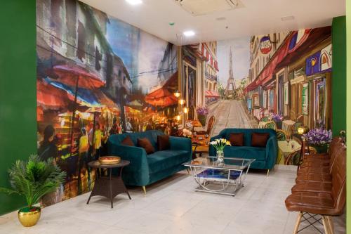 a living room with a large painting on the wall at The Monarch Hotel Bagalur IT Park in Bengaluru