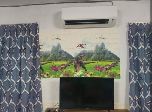 a tv in a room with a painting on the wall at Village Retreat Jetty Kuala Perlis in Kuala Perlis