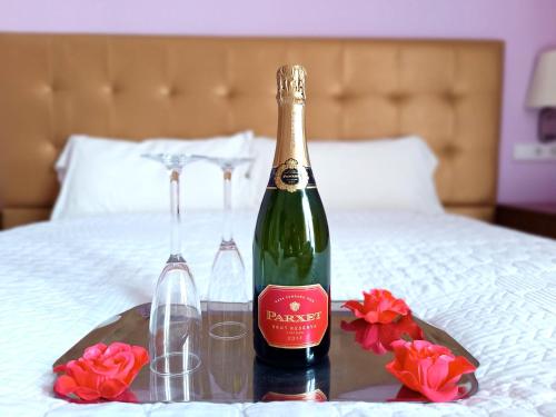 a bottle of champagne and two glasses on a bed at Hotel Llar de Capitans in Masnou