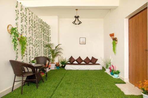 a living room with a green lawn in the middle at The Monarch Hotel Bagalur IT Park in Bengaluru