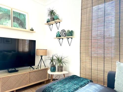 sala de estar con TV de pantalla plana y plantas en Oliva Nova Playa Golf MET, en Oliva