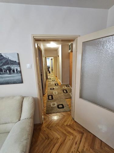 a living room with a couch and a hallway with rugs at Apartman Maks 2 in Pirot