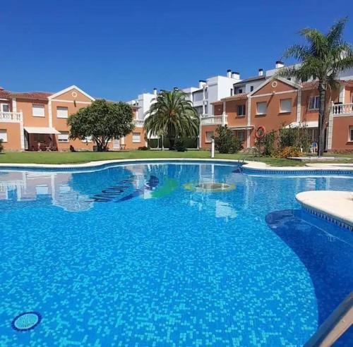 Una gran piscina azul con edificios al fondo. en Oliva Nova Playa Golf MET, en Oliva