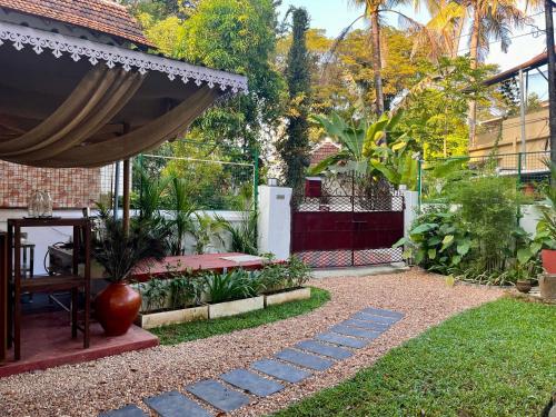 a patio with a hammock in a garden at Scarlet's Cottage & Tea Garden in Cochin