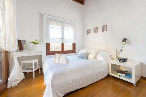 een witte slaapkamer met een bed en een raam bij Katerina Boutique Villa in Rhodos-stad
