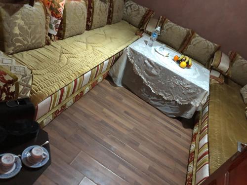a small room with a couch with a table on it at Hagounia hotel in Tan-Tan