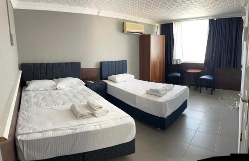 a hotel room with two beds and a table at Grand asia otel in Seferihisar