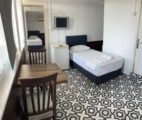 a small hotel room with a bed and a table at Grand asia otel in Seferihisar