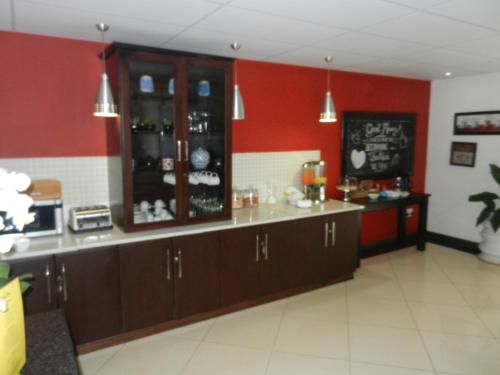 una habitación con un bar con paredes rojas en Regal Inn Ballito, en Ballito