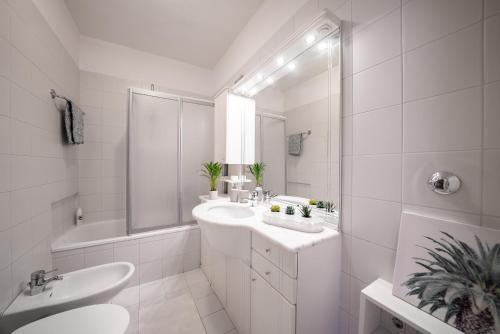 a white bathroom with a sink and a tub at Apartment Schoenblick in Caldaro