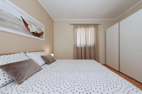 a bedroom with a large bed and a window at Antonija in Bašić