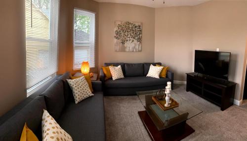 a living room with a blue couch and a television at 4 Bedroom, 2 full bath whole house in Hamilton