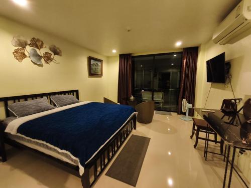 a bedroom with a bed and a living room at The Pixel Cape Panwa Beach Condo in Panwa Beach