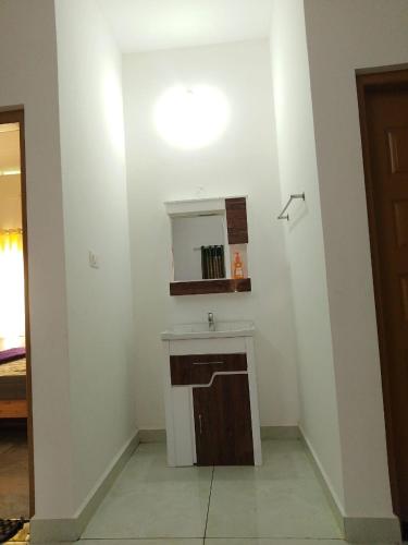 a bathroom with a sink and a mirror at Ashvis cottage in Thekkady