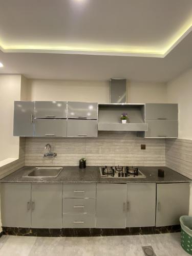 a kitchen with white cabinets and a sink at Entire Holiday Home in Galiyat with Valley Views in Khaira Gali