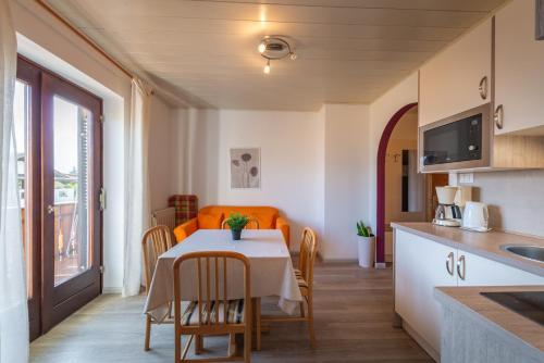 a kitchen and dining room with a table and chairs at Apartments Burgunderhof in Termeno