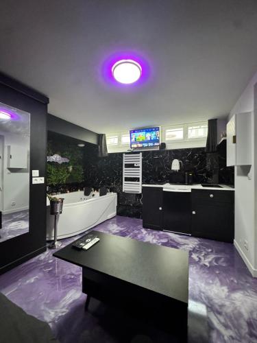 une grande cuisine avec une table et un sol violet dans l'établissement Nid d'amour, à Trouville-sur-Mer