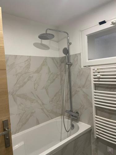 La salle de bains est pourvue d'une douche et d'un mur en marbre. dans l'établissement Maison moderne proche CDG, à Aulnay-sous-Bois