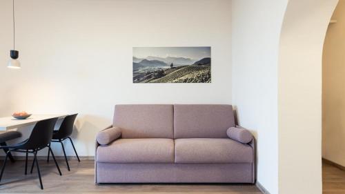 a living room with a couch and a table at Apartments Hofgarten in Caldaro