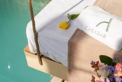 a table with a towel and flowers on it at Casadar Guesthouse in Ash Shi‘b