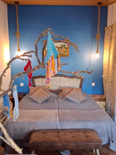 a bedroom with a bed with a tree branch on it at Pateo da Memória-Casa do Artesão in Quinta do Anjo
