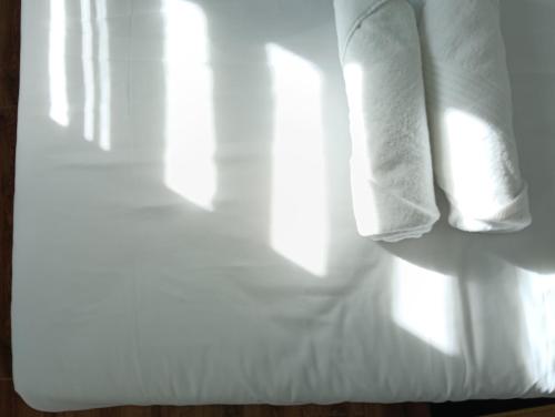 a stack of white towels sitting on a bed at H62 Muar Home in Muar