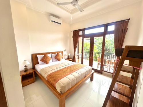 a bedroom with a bed and a balcony at Naeera Guest House in Ubud