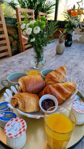 Résidence belle créole I Le Balisier I Duplex avec jacuzzi à 15min de Disneyland Paris في Quincy-Voisins: طبق طعام على طاولة مع المعجنات