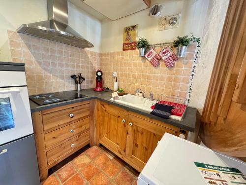 une petite cuisine avec un évier et une cuisinière dans l'établissement L'Évasion Alsaciene, à Wintzenheim
