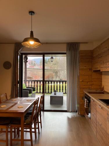 una cucina e una sala da pranzo con un tavolo e una grande finestra di Moolys place a Buşteni