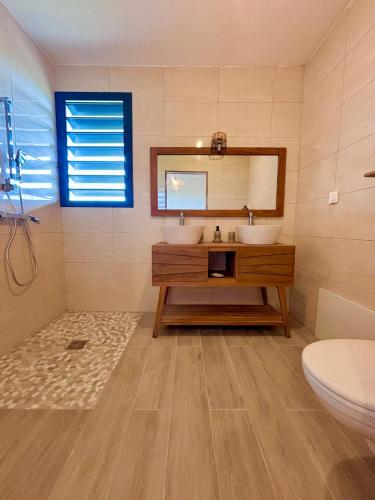 a bathroom with two sinks and a mirror at Villa Vincent des Caps in Le Marin