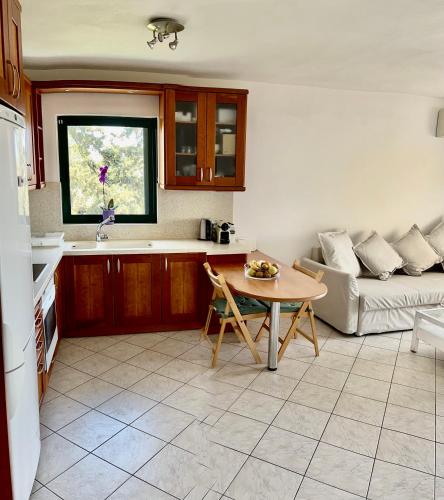 a kitchen and living room with a table and a couch at Thedreamlifehouse in Anavissos