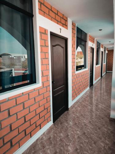 a brick wall with a door in a hallway at Huacachina Desert House in Ica