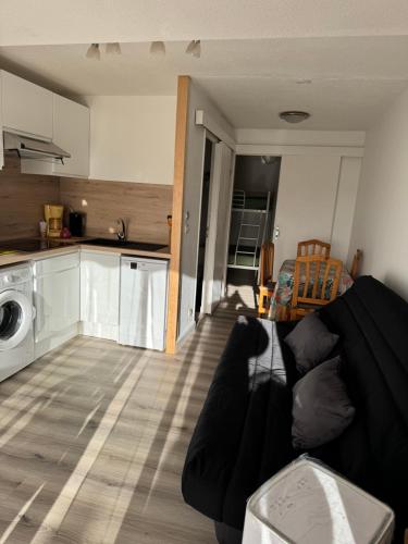 un salon avec un canapé et une cuisine dans l'établissement Appartement les pieds dans l’eau !, à Marseillan