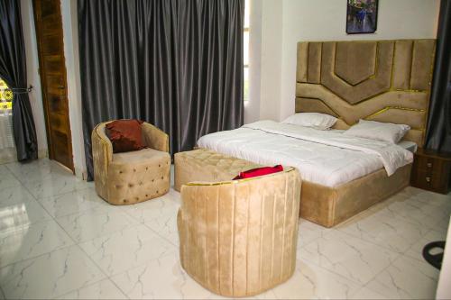 a bedroom with a large bed and a chair at Mclanraysterlin in Lagos Island