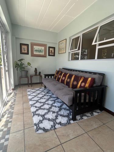 a living room with a bed and a rug at The Milkwood Place in Kommetjie